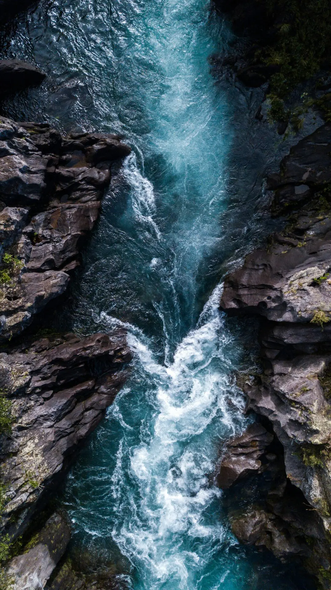 Blue river water flowing between rocky banks